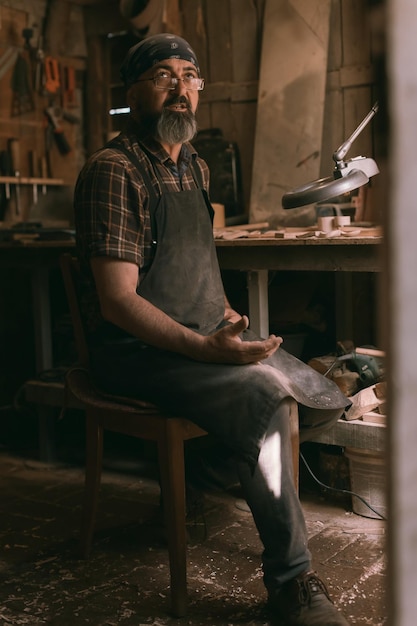 Il maestro del cucchiaio nella sua bottega con prodotti e strumenti in legno. Foto di alta qualità