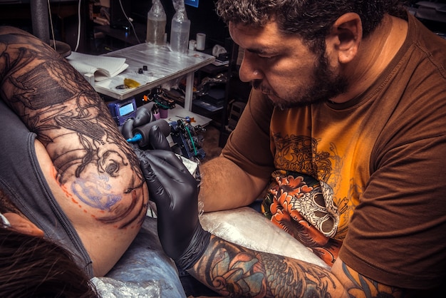 Il maestro del tatuaggio crea il tatuaggio in studio.