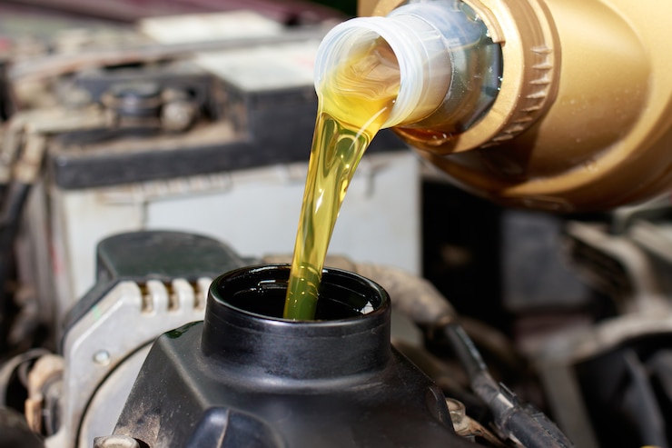Foto il maestro della manutenzione dell'auto versa olio motore per il motore dell'auto.