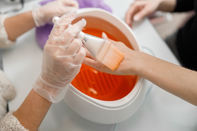 Il maestro di manicure professionale sta facendo le unghie per il cliente nel salone di bellezza