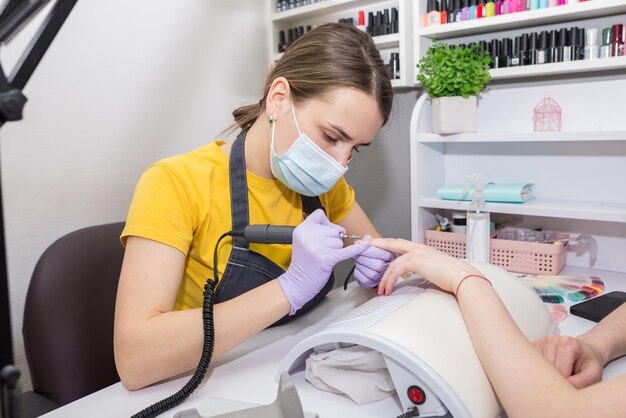 Il maestro fa al cliente una manicure in un salone di bellezza.