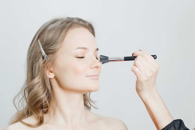 Il maestro fa un bellissimo trucco biondo in un salone di bellezza