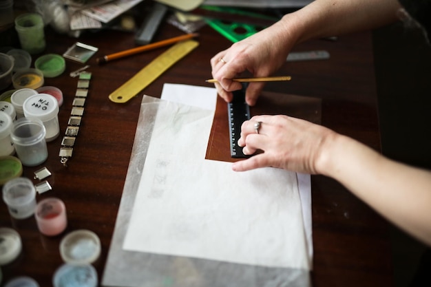 Il maestro nel laboratorio creativo sta lavorando allo smalto del prodotto per il disegno metallico