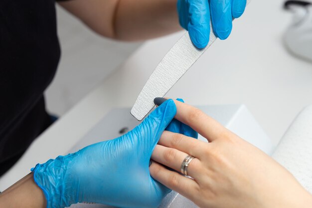 Il maestro nel salone di bellezza fa una manicure alla ragazza.