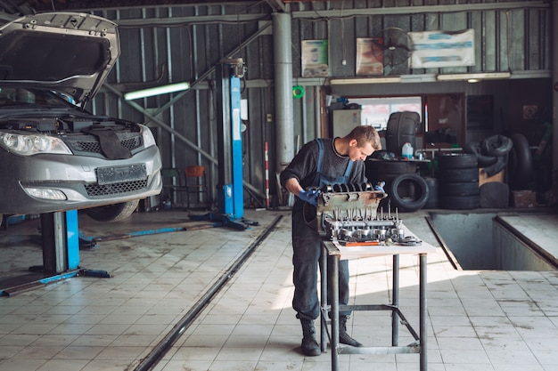 Il Maestro raccoglie un motore ricostruito per l'auto.