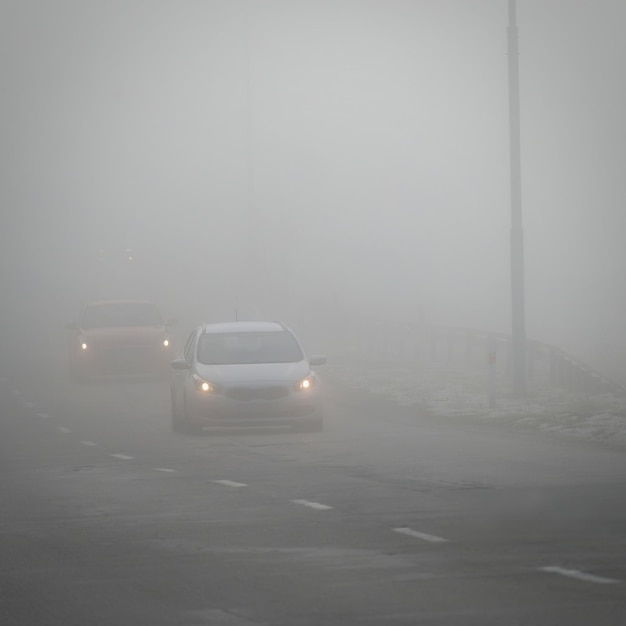 Il maltempo alla guida di una strada di campagna nebbiosa e nebbiosa Traffico stradale autostradale Orario invernale