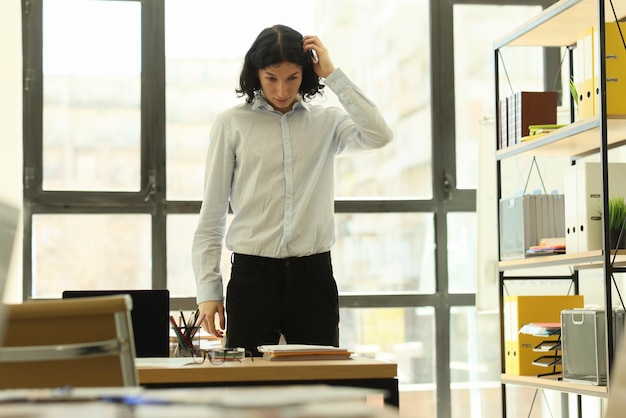 Il manager confuso con i capelli lunghi pensa alle idee per il progetto