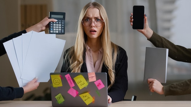 Il manager multitasking della donna d'affari in ufficio al tavolo ha molti compiti che si sentono stressati oberati di lavoro