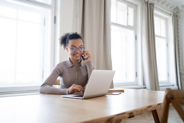 Il manager sorride e usa un nuovo laptop e telefono per lavoro Scrive una libera professionista