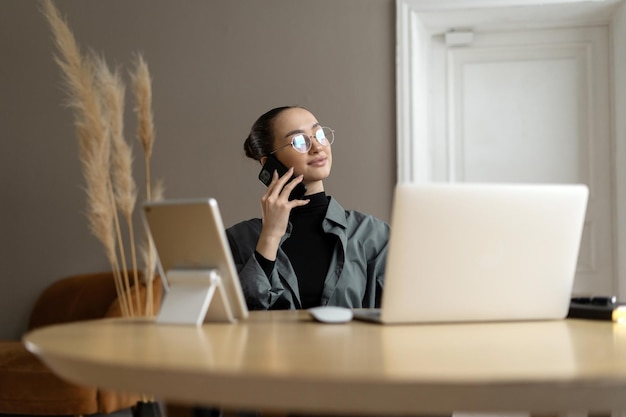 Il manager una donna elegante con gli occhiali utilizza un computer portatile in un ufficio moderno scrive un messaggio