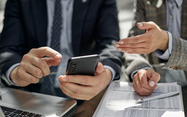 Il manager utilizza lo smartphone mentre è seduto a tavola con un collega