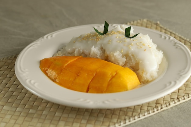 Il mango con riso appiccicoso è un dolce tipico tailandese a base di riso glutinoso e salsa al latte di cocco.