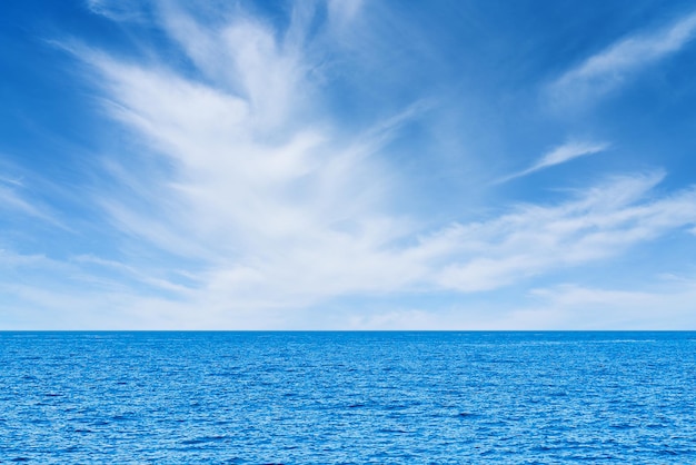 Il mare blu e le nuvole bianche sullo sfondo dell'orizzonte della nuvola d'acqua del cielo si sentono calmi e rilassanti sull'oceano