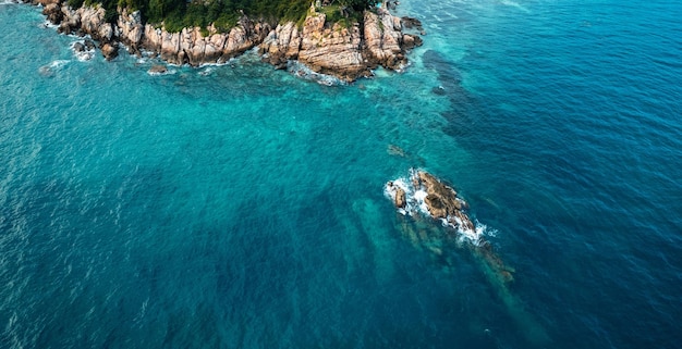 Il mare blu e le rocce dell'isola formano sopra