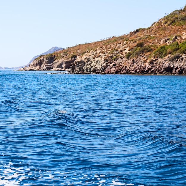 Il mare blu ondeggia il bellissimo litorale roccioso naturale e le isole Concetto di natura costiera per le vacanze estive