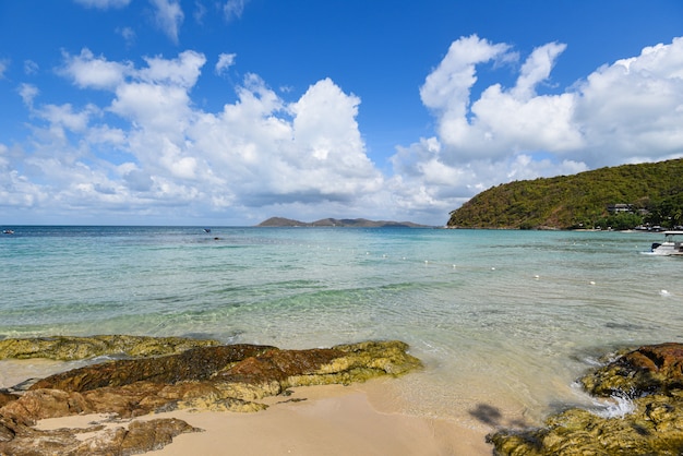 Il mare ondeggia sulla costa rocciosa di vista sul mare dell'acqua e della costa della spiaggia di sabbia. Vista di bella isola tropicale del mare della spiaggia del paesaggio con il cielo blu dell'oceano e il fondo della località di soggiorno nella vacanza della spiaggia di estate della Tailandia