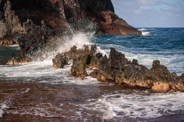 Il mare si scontra con le pietre e la sabbia di una spiaggia, le onde del mare, la linea delle ciglia impattano la roccia