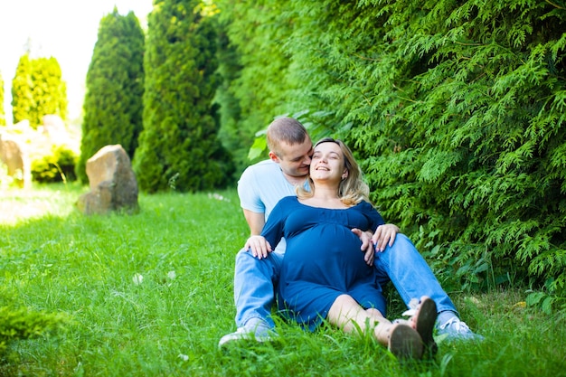 Il marito sorridente con la moglie incinta sta riposando sulla natura