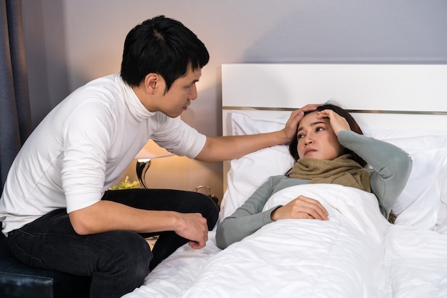 Il marito visita e si prende cura della moglie malata mentre è sdraiata sul letto a casa