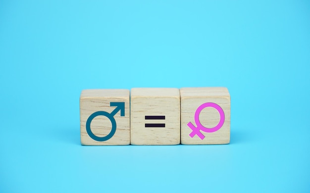 Il maschio è uguale al simbolo dell'icona femminile sul blocco di legno su priorità bassa blu