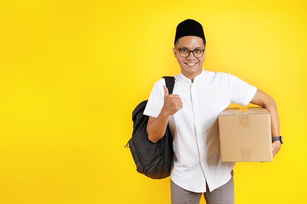 il maschio musulmano asiatico che trasporta la scatola di cartone e lo zaino si prepara per il ritorno a casa di eid mubarak