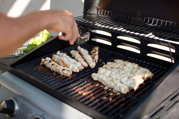 Il maschio prepara il barbecue all'aperto