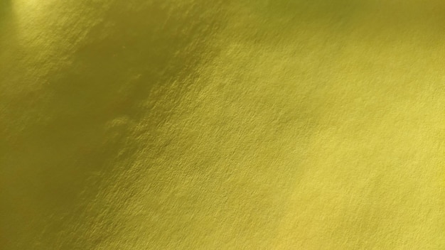 Il materiale della carta o del tessuto è di colore giallo brillante Primo piano Foglio leggermente piegato Sfumatura leggera e superficie ruvida accentuata Sfondo o campione di prodotto Giallo soleggiato e allegro