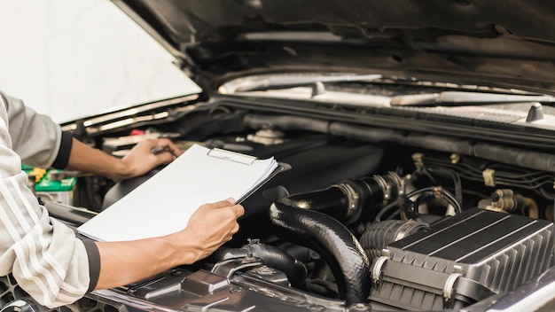 Il meccanico lavora al motore dell'auto in garage