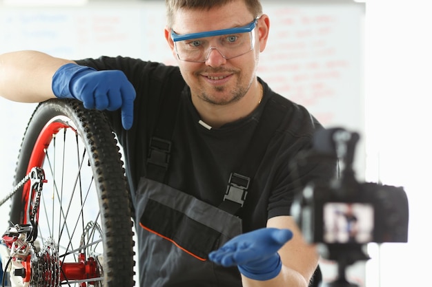 Il meccanico professionista ripara la bicicletta in un'officina moderna e registra video