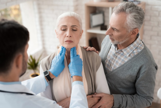 Il medico controlla i linfonodi della donna anziana.