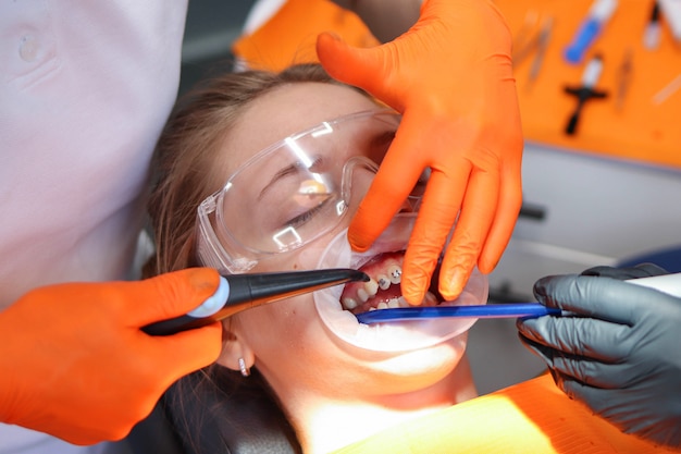 Il medico dentista installa apparecchi ortodontici per il suo paziente