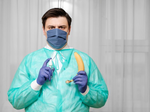 Il medico disinfetta la banana, lo spray antisettico per la lavorazione della frutta