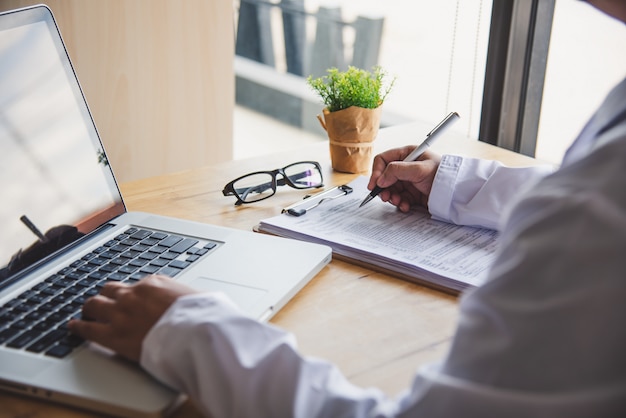 Il medico è seduto lavoratore sul computer portatile