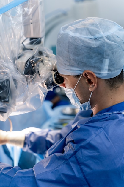 Il medico esegue un chirurgo minimamente invasivo utilizzando un dispositivo robotico. Operazione sul cervello. Messa a fuoco selettiva.