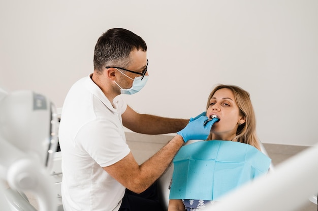 Il medico inserisce il portaimpronta e realizza il calco dei denti al paziente in odontoiatria prima dell'impianto dentale Procedura di creazione di corone e allineatori di protesi dentarie