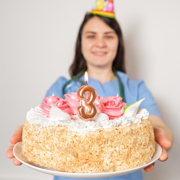 Il medico o l'infermiere tiene una torta di compleanno