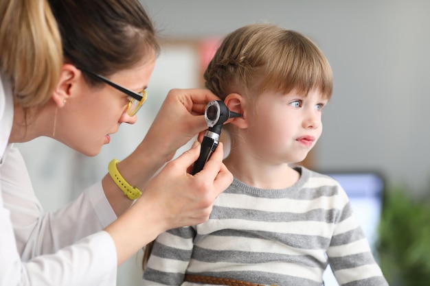 Il medico ORL conduce l'esame fisico dell'orecchio della bambina