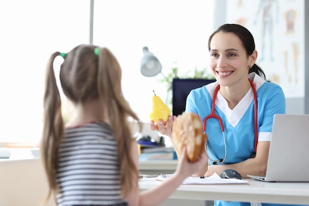 Il medico pediatra dice alla bambina i benefici di un'alimentazione sana