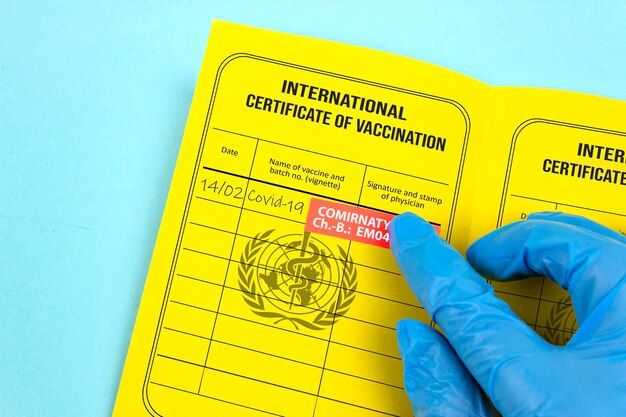 Il medico scrive la vaccinazione booster contro il Covid 19 registrata nel certificato di vaccinazione giallo