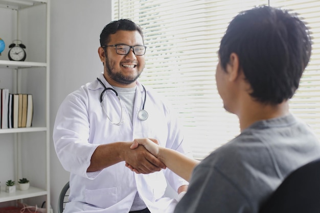 Il medico sorridente felice saluta il suo paziente stringendo la mano