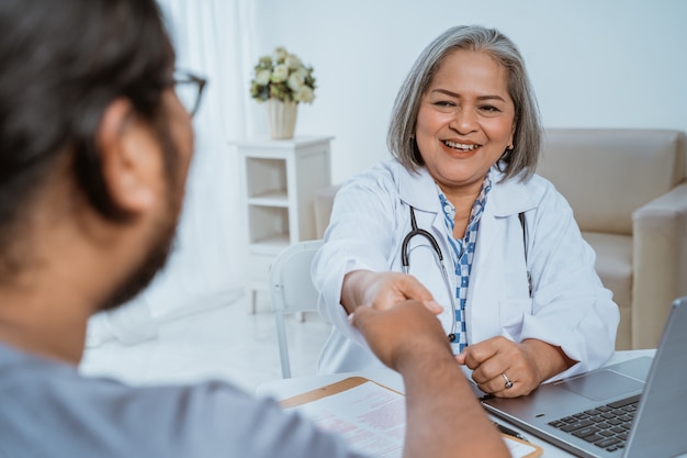 Il medico stringe la mano al paziente