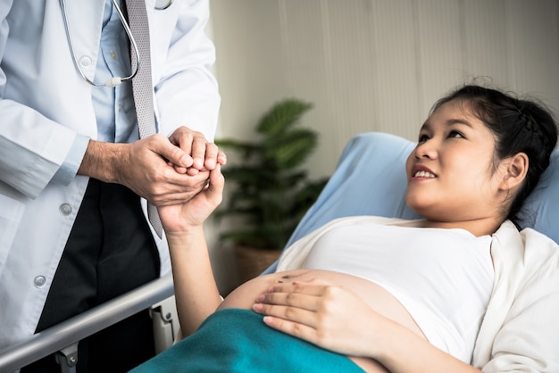 Il medico tiene le mani del paziente donna