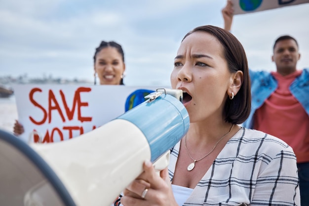 Il megafono del cambiamento climatico e la donna asiatica protestano con la folla che protesta per l'ambiente e il riscaldamento globale Salva l'attivismo del gruppo terrestre e le donne urlano sull'altoparlante per fermare l'inquinamento del pianeta