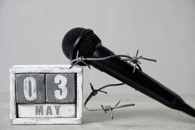 Il microfono nero è avvolto con filo spinatoIn calendario 3 maggioConcetto per la Giornata della libertà di stampa