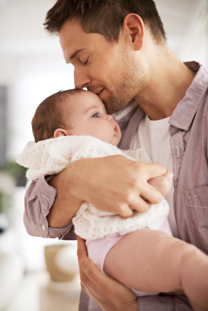 Il mio angioletto Inquadratura di un giovane padre che tiene in braccio la sua adorabile bambina e mostra il suo affetto