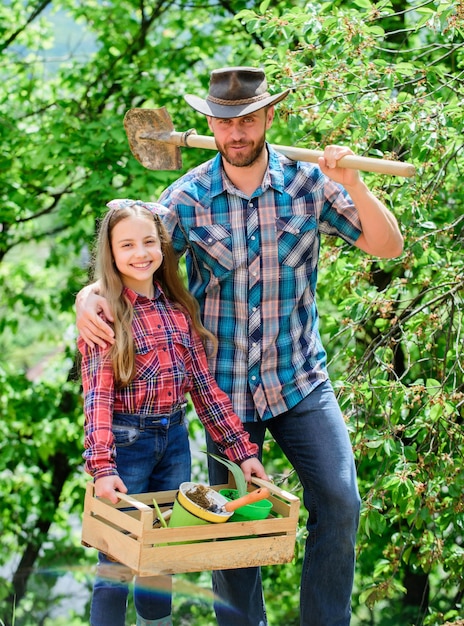 Il mio lavoro è la mia passione villaggio di primavera campagna bambina e uomo felice papà giorno della terra nuova vita ecologia ambiente suoli e fertilizzanti fattoria di famiglia agricoltura padre e figlia in ranch