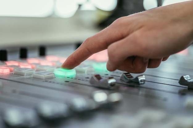 Il moderatore dello studio di trasmissione radiofonica utilizza il computer della tavola armonica in background