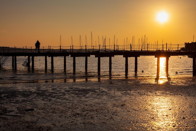 Il molo al tramonto Ponte boscoso sul mare con Tramonto Strugnano Slovenia