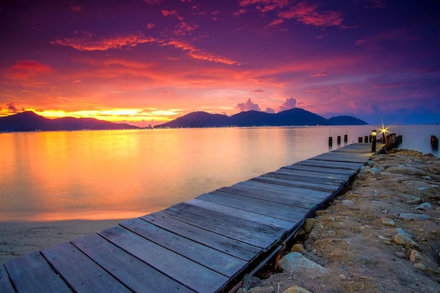 Il molo sopra il lago contro il cielo durante il tramonto