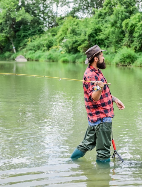 Il momento migliore per andare a pescare fine settimana estivo Pesca d'altura uomo maturo pesca a mosca uomo che cattura pesce hobby e attività sportive cacciatore di pesci pescatore con la barba in acqua pescatore con canna da pesca